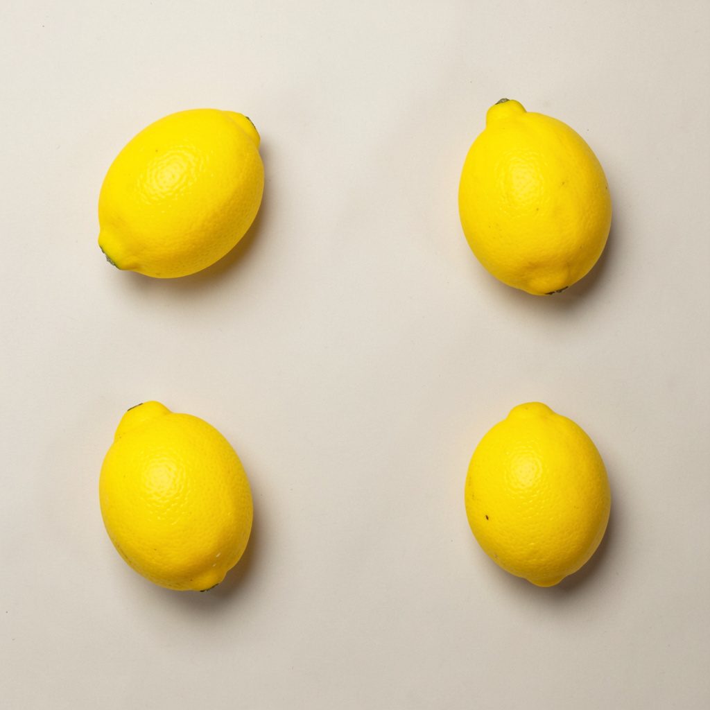 Overhead flat-lay photograph of a roulette wheel segment and betting chips on a matte black tabletop, captured from directly above under cool white light with a single safety-yellow chip as accent.